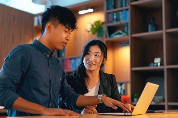 Two people looking at a laptop